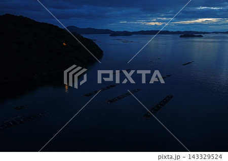 愛媛県宇和島市の養殖いかだと沿岸の夕暮れを捉えた空撮写真 愛媛県宇和島市の養殖いかだと沿岸の夕暮れを捉えた空撮写真 143329524
