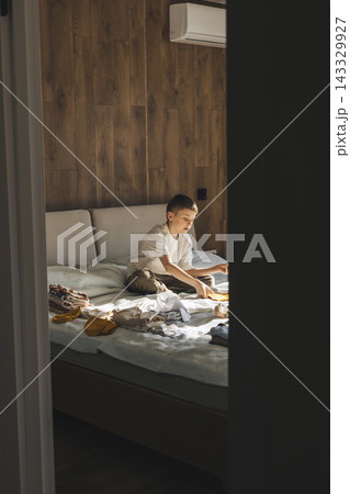 Older Brother Preparing Baby Clothes for New Sibling at Home Older Brother Preparing Baby Clothes for New Sibling at Home 143329927
