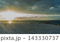 夕暮れの海岸と雲の間から広がる夕光 白い石浜と連絡橋の景観写真素材 143330737