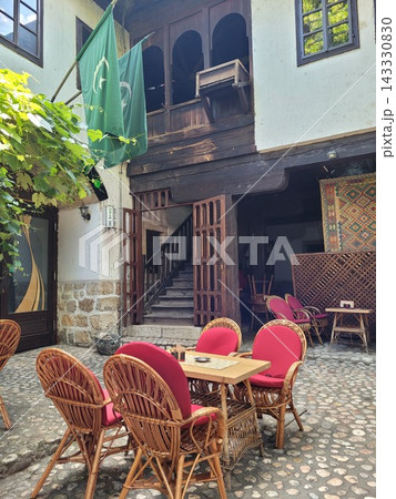 Bascarsija courtyard cafe with Ottoman architecture and flags 143330830