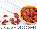 Bowl with dehydrated red fragrant tomatoes with herbs and spices. 143330946