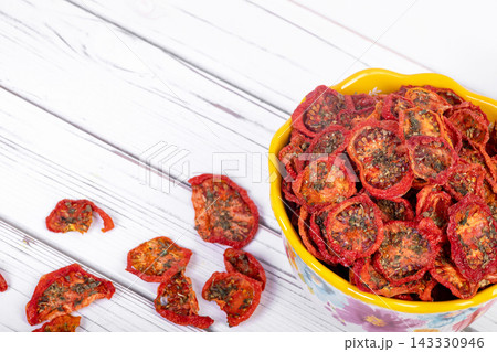 Bowl with dehydrated red fragrant tomatoes with herbs and spices. 143330946