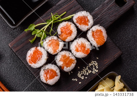 Sushi roll with tuna, rice, and cream cheese, served with soy sauce, wasabi, and ginger. Tuna roll 143331738