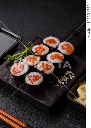 Sushi roll with tuna, rice, and cream cheese, served with soy sauce, wasabi, and ginger. Tuna roll 143331739