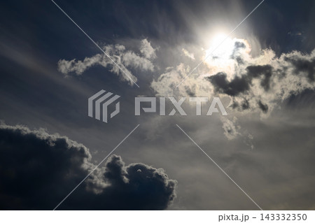 bright sun breaking through dark cumulus clouds in a dramatic cloudy sky bright sun breaking through dark cumulus clouds in a dramatic cloudy sky 143332350