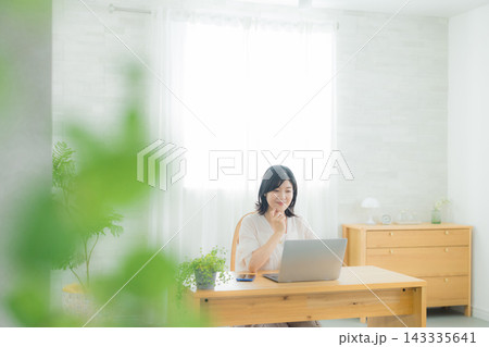 リビングでパソコンを見る女性 リビングでパソコンを見る女性 143335641