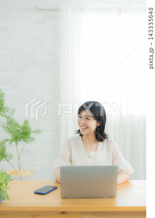 リビングでパソコンを見る女性 リビングでパソコンを見る女性 143335648