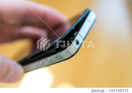バッテリーが膨張して背面パネルが外れたスマホ 143336571