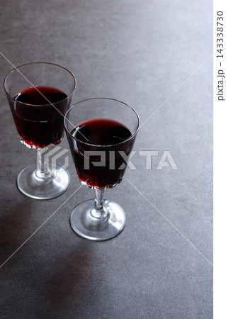 赤ワインで乾杯 - 赤ワインが注がれたふたつのワイングラスで、乾杯をしているイメージ 143338730