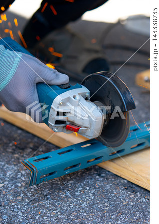Worker cutting metal with many sharp sparks using equipments to cut iron 143338735
