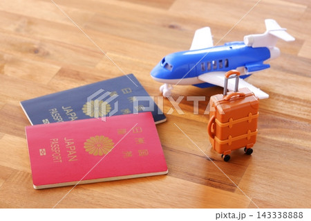 パスポートとスーツケース - 海外旅行の準備のため、スーツケースとパスポートを用意する 143338888