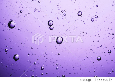 Purple liquid filled with many small and large floating bubbles creating abstract texture Purple liquid filled with many small and large floating bubbles creating abstract texture 143339017