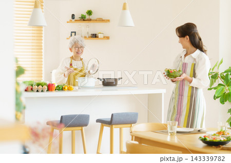 キッチンで料理をするミドルエイジの日本人女性2人 キッチンで料理をするミドルエイジの日本人女性2人 143339782