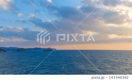 夕暮れ時の広大な海とダイナミックな雲の広がり 夕暮れ時の広大な海とダイナミックな雲の広がり 143340392