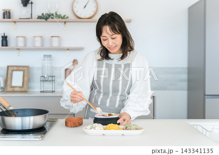 キッチンでお弁当を詰める女性（お母さん,妻,主婦） 143341135