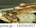 大根おろしを添えた焼きサンマを箸で味わう秋の和食 143341857