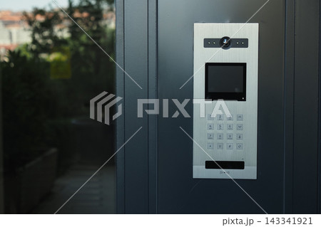 Door intercom system located outside a building entrance with number pad Door intercom system located outside a building entrance with number pad 143341921