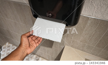 Person using touchless paper towel dispenser in a restroom Person using touchless paper towel dispenser in a restroom 143341946