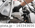 • エンジンオイルの量と汚れをレベルゲージで点検する自動車整備士 143343656