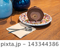 Chocolate Banana Roll Cake Slice on Colorful Plate with Spoons on Wooden Table 143344386