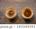 Two cups of coffee on a wooden table 143344391