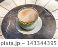 A cup of frothy coffee on a marble table 143344395