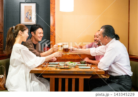 居酒屋で飲み会をする男女 143345229