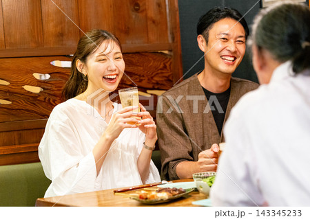 居酒屋で飲み会をする男女 居酒屋で飲み会をする男女 143345233