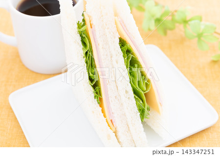 美味しいハムチーズレタスサンドとコーヒーのモーニング 143347251