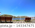 快晴の青空と湖畔に並ぶ木製ベンチの開放的な景色 143347475