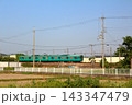青空と緑の田畑を抜けて走るローカル列車 143347479
