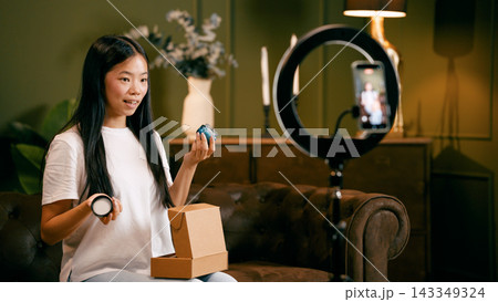 Young woman creating content for a product review video Young woman creating content for a product review video 143349324