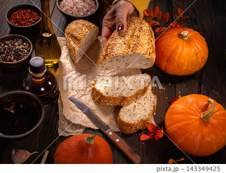 Hand serving rustic seeded bread with autumn ingredients Hand serving rustic seeded bread with autumn ingredients 143349425