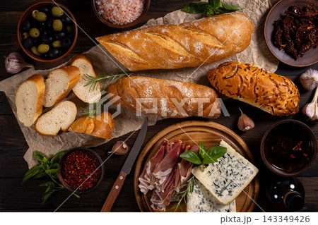 Assorted antipasto ingredients creating a rustic spread 143349426