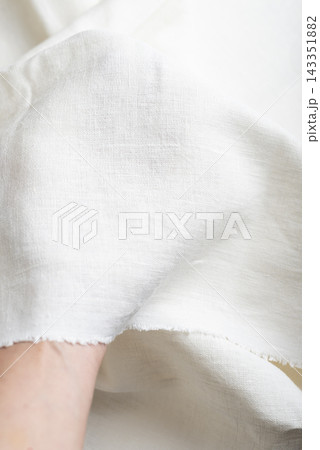 Hand Holding Off White Linen Fabric Edge Hand Holding Off White Linen Fabric Edge 143351882