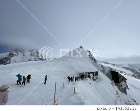 【スイス】ユングフラウヨッホの雪原を歩く観光客とアルプスの雪景色 143352215