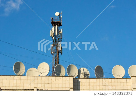 Telecommunication tower and satellite dishes on rooftop Telecommunication tower and satellite dishes on rooftop 143352373