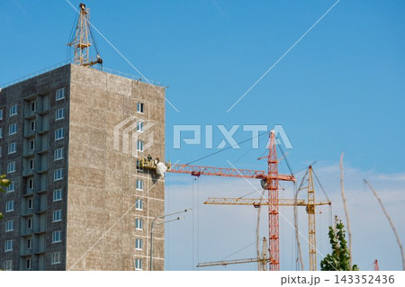 High-rise building construction site with tower cranes and sustainable green development 143352436