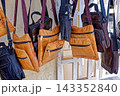 Hanging Display of Handcrafted Leather Messenger Bags and Shoulder Pouches with Zippers 143352840