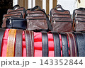 Market Display of Handcrafted Leather Shoulder Bags and Embossed Accessories on Vibrant Fabric 143352844