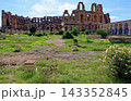Wide Dynamic Shot of Ancient Roman Amphitheatre of El Jem with Grassy Foreground and Archways 143352845