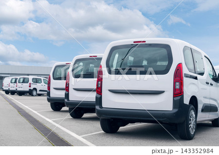 White delivery vans are parked in rows. Commercial fleet of vehicles White delivery vans are parked in rows. Commercial fleet of vehicles 143352984