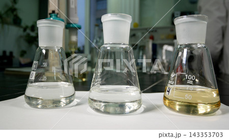 Three test tubes with liquids of different colors standing on a table in a chemical laboratory 143353703