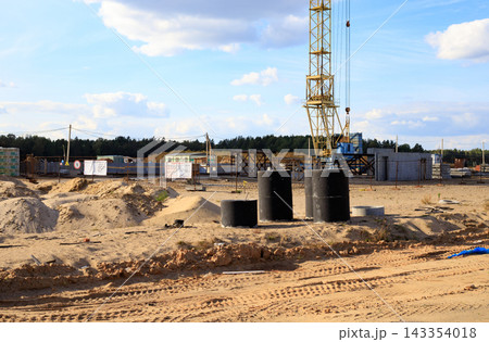 Yellow tower crane at a construction site. Use of heavy machinery and construction work. Yellow tower crane at a construction site. Use of heavy machinery and construction work. 143354018