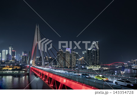 Chongqing city nightscape featuring the glowing red architecture of the Qiansimen Bridge over the Jialing River. A sweeping vista of the illuminated Jiangbeizui financial district skyscrapers and busy Chongqing city nightscape featuring the glowing red architecture of the Qiansimen Bridge over the Jialing River. A sweeping vista of the illuminated Jiangbeizui financial district skyscrapers and busy 143354728