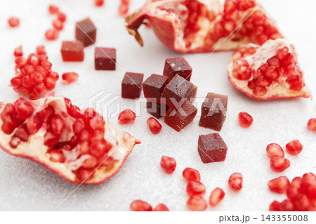 Candied fruit jelly with pomegranate fruits on white. Flat lay Candied fruit jelly with pomegranate fruits on white. Flat lay 143355008
