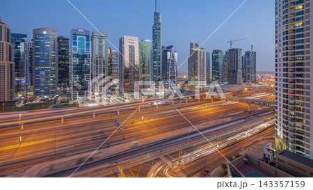 Aerial view of Jumeirah lakes towers skyscrapers day to night timelapse with traffic on sheikh zayed road. Aerial view of Jumeirah lakes towers skyscrapers day to night timelapse with traffic on sheikh zayed road. 143357159
