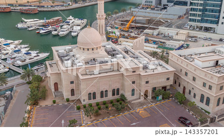 Yachts in Dubai Marina flanked by the Al Rahim Mosque and residential towers and skyscrapers aerial night to day timelapse. Yachts in Dubai Marina flanked by the Al Rahim Mosque and residential towers and skyscrapers aerial night to day timelapse. 143357201