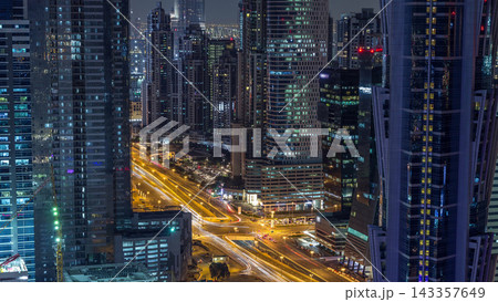 Aerial view of towers in Business Bay with traffic on the road night timelapse. Aerial view of towers in Business Bay with traffic on the road night timelapse. 143357649