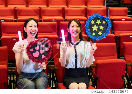 コンサートの客席でアイドルを応援する二人の女性ファン コンサートの客席でアイドルを応援する二人の女性ファン 143358675